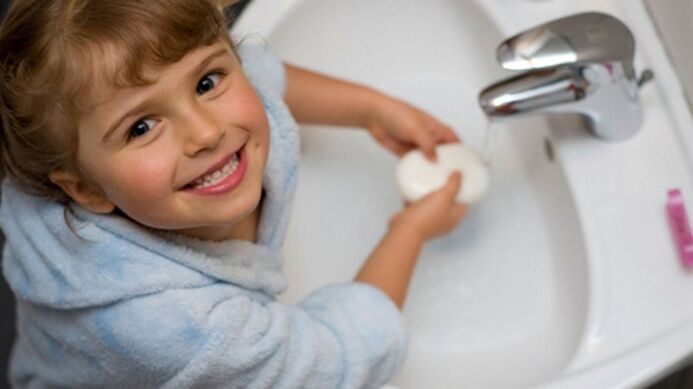 copilul se spală pe mâini cu săpun pentru a preveni viermii